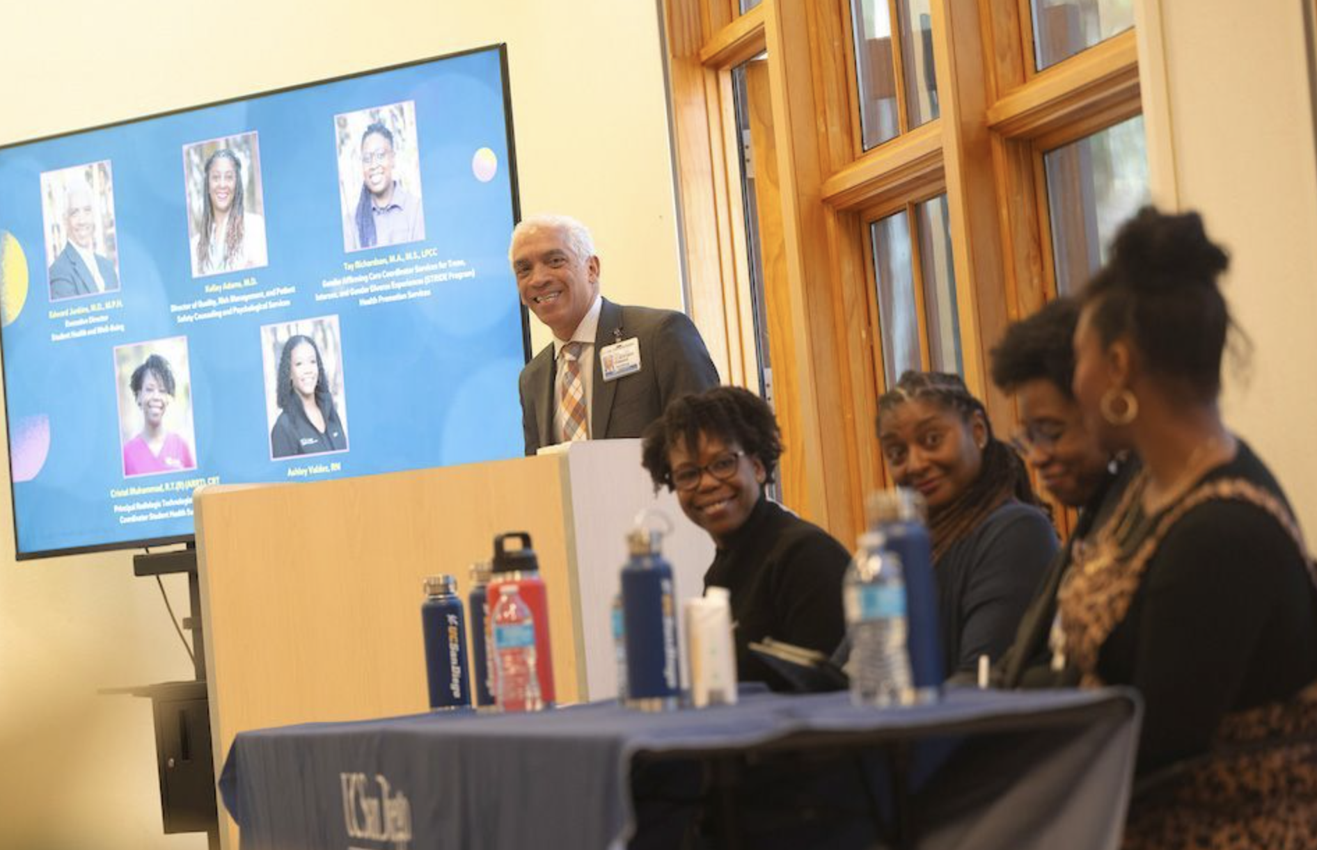 A photo of Black healthcare professionals smiling while speaking on a panel.